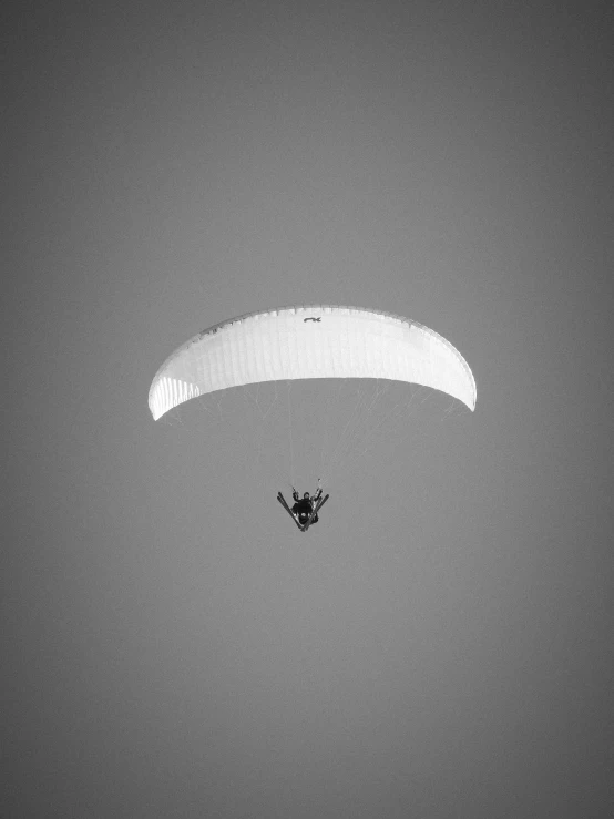 a person that is flying in the sky with a parachute