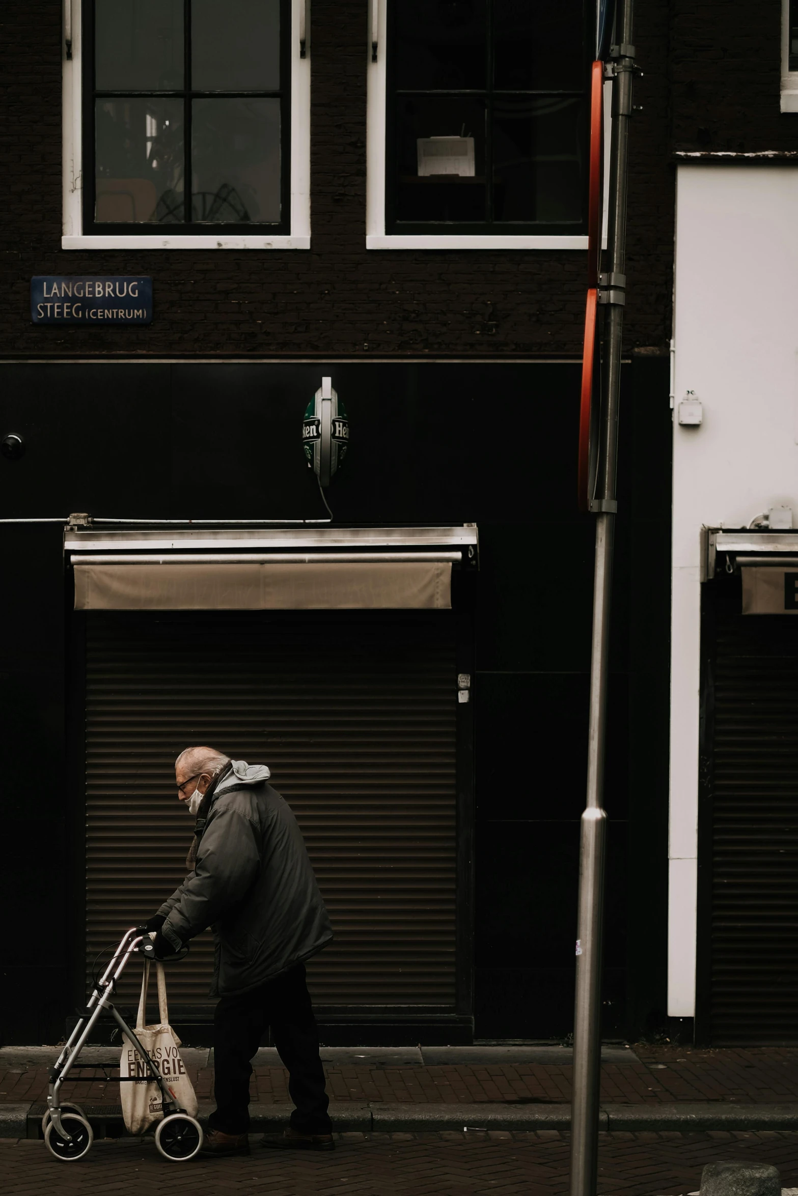 man with stroller walking on sidewalk in urban setting