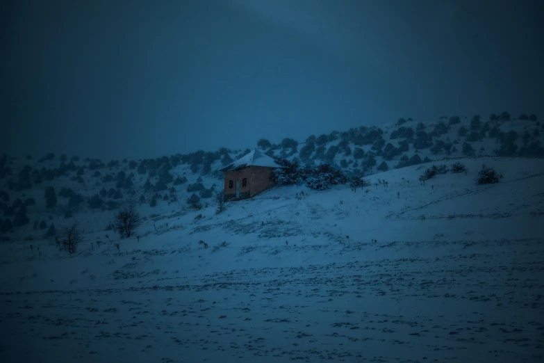 there is a small house on top of the snow covered hill