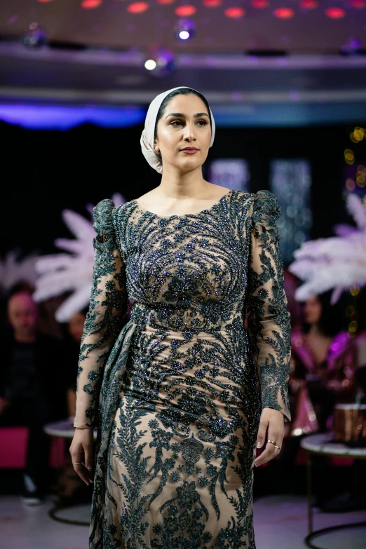 a model walking down the catwalk in an elaborate gown