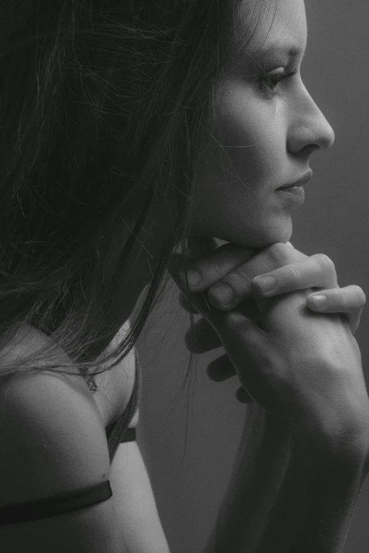 a woman with her hands together posing for a portrait