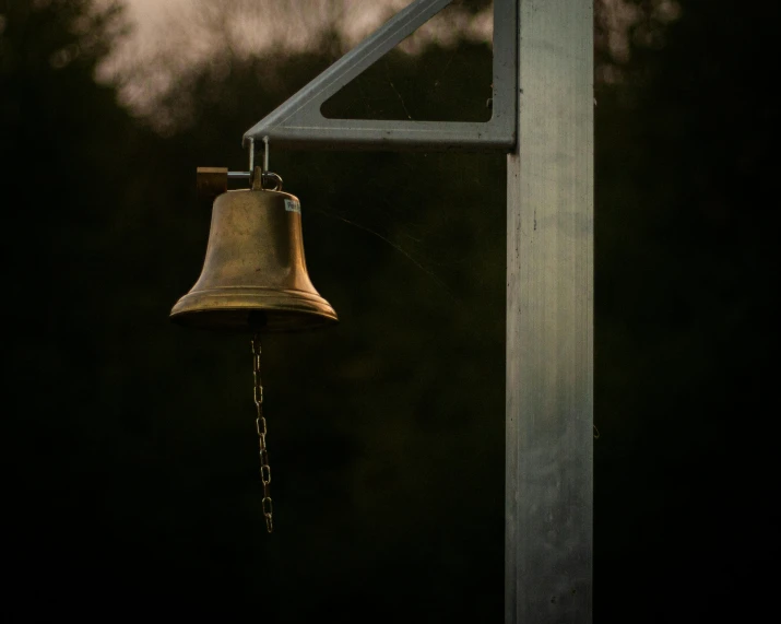 a bell attached to a light on a metal pole