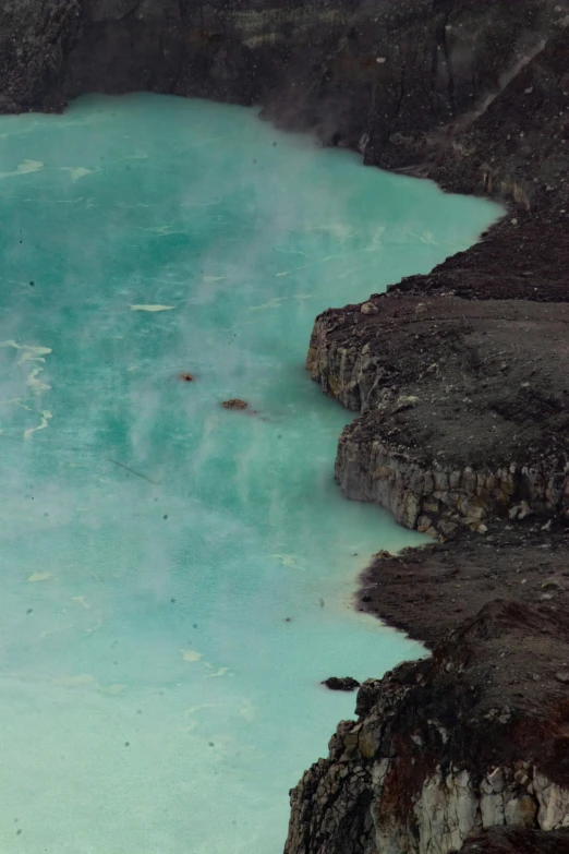 there is a small patch of blue water in the mountains