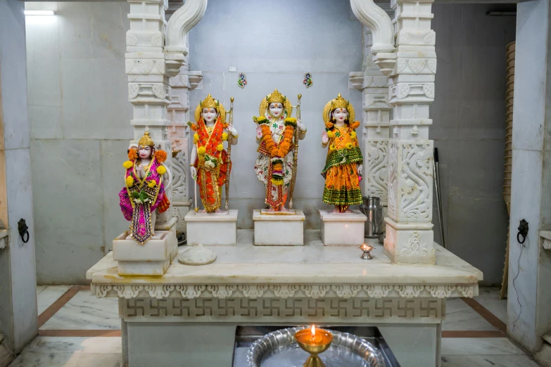 several different statues of women holding flowers in a room