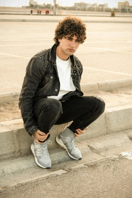 a man sits on steps holding his legs