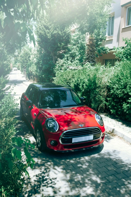 the front view of a red, small mini -van parked on a paved street