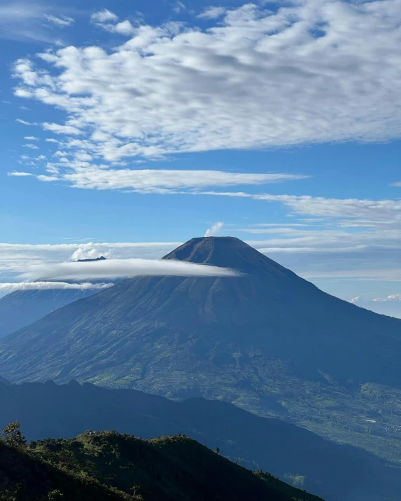 the mountain has a cloud hovering over it