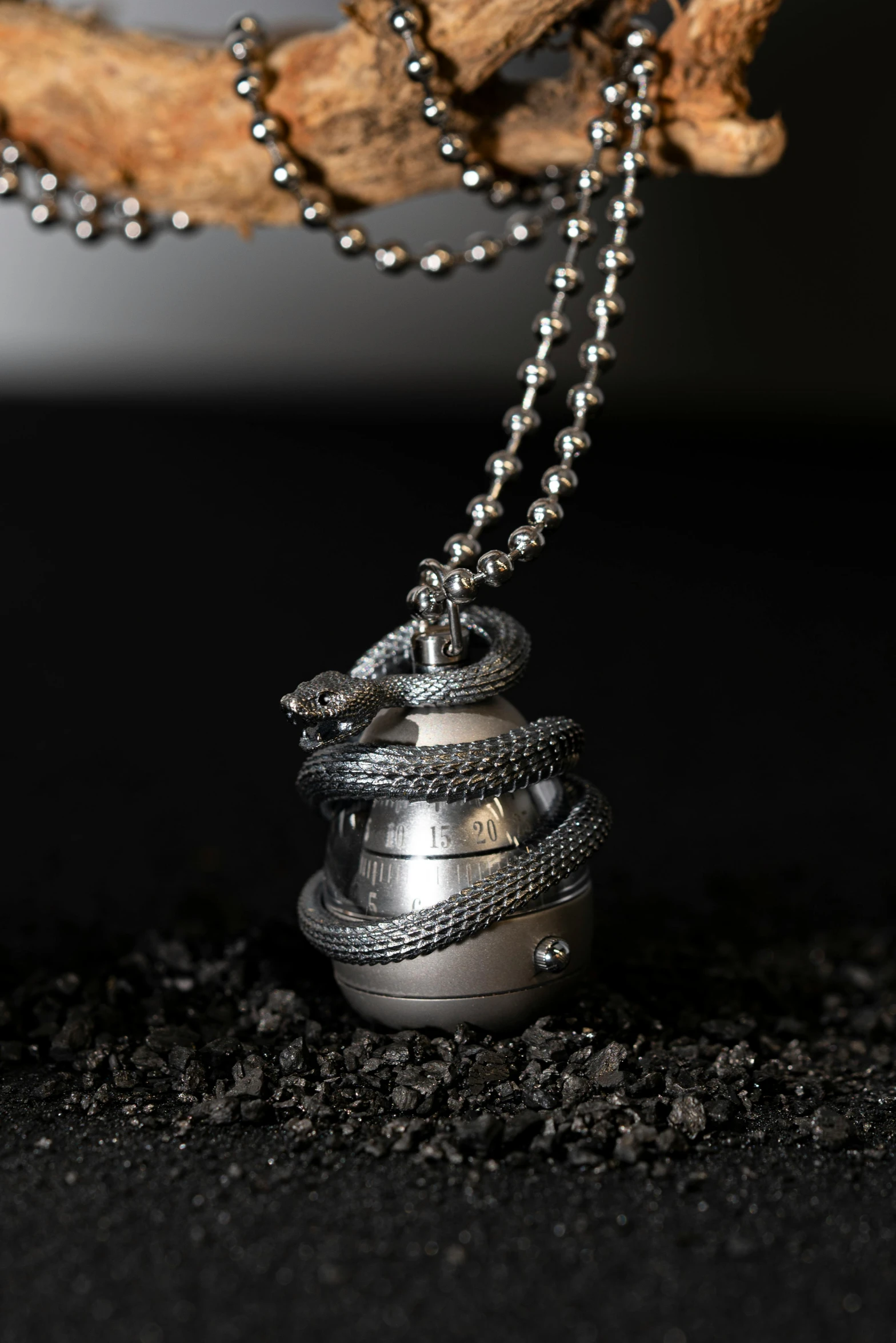 two pieces of jewelry sit on top of a chain