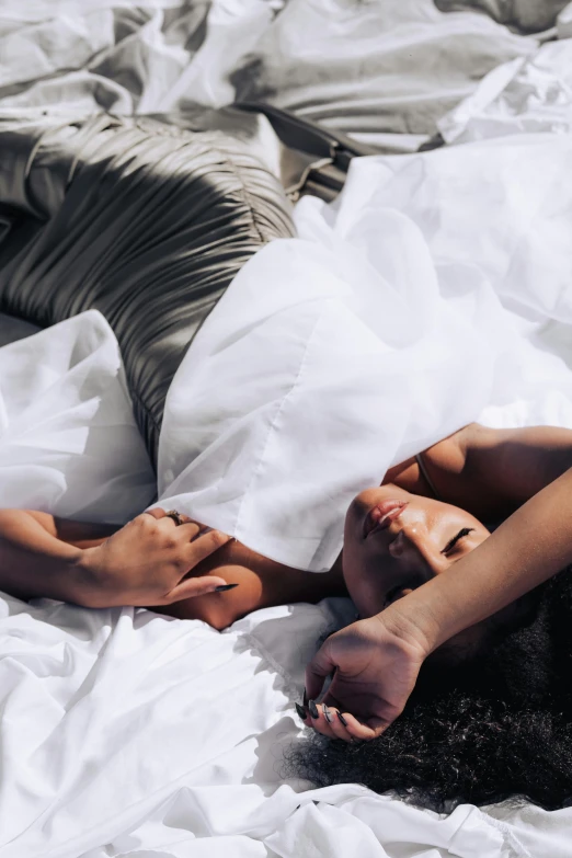 a woman laying down under a blanket in the daytime