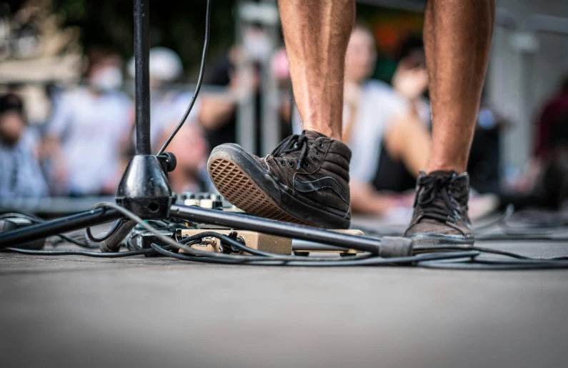 the legs of a person standing with a scooter