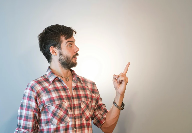 a man with a beard and beard holding a finger up