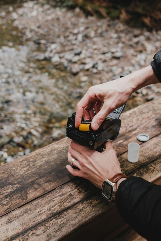 a man uses a small lighter on a bench