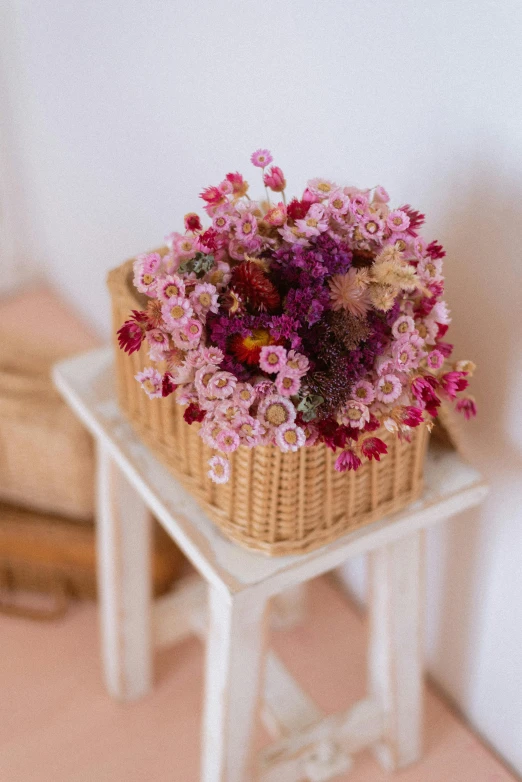 a basket of flowers on top of a stool