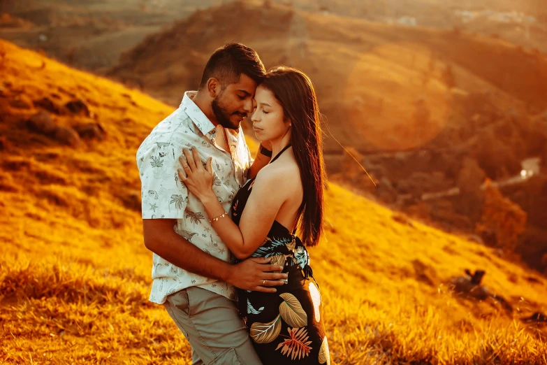 a man and a woman emcing each other on top of a hill