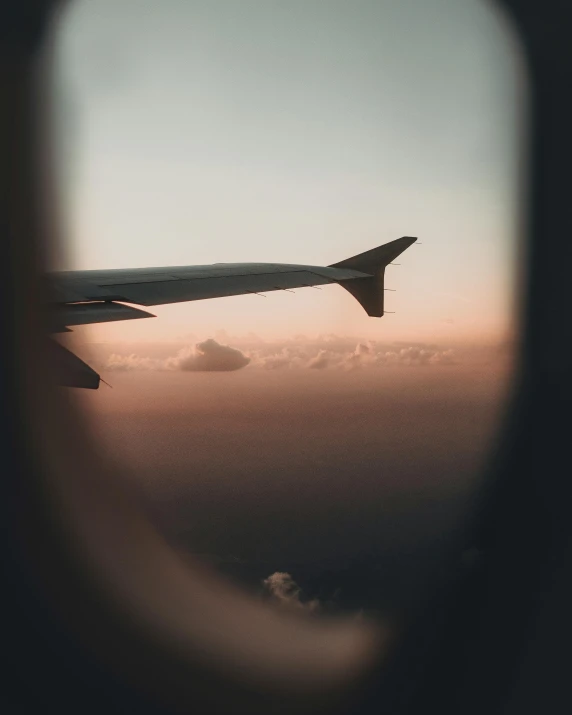 an airplane wing and some clouds in the sky