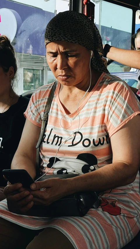 a woman using a cell phone while seated on the bus