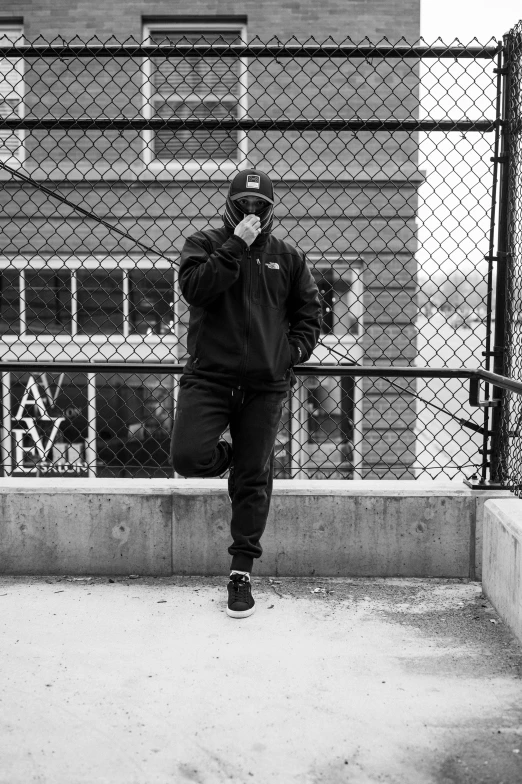 a man walks with his cellphone on a city sidewalk