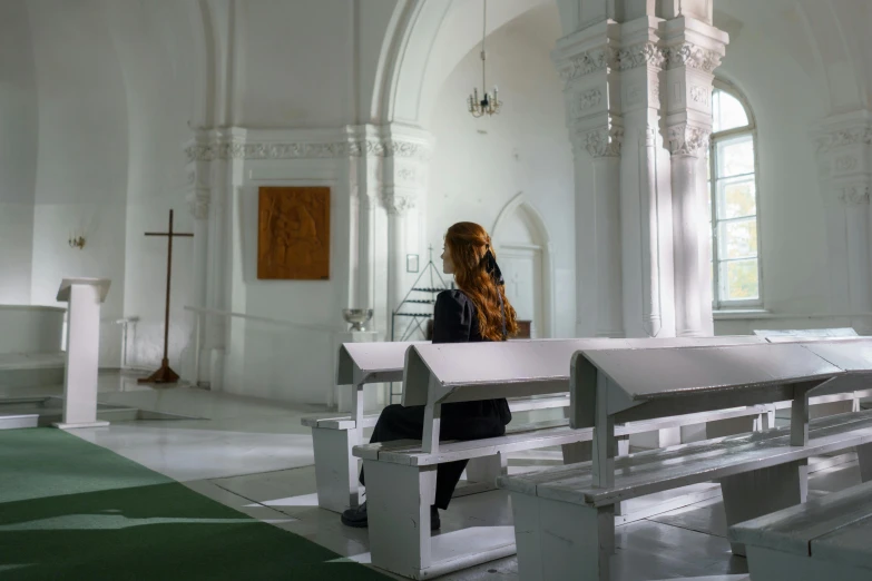 woman sitting in church with the light on her feet