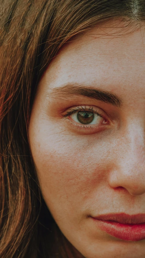 a woman with freckles on her eyes and light brown hair