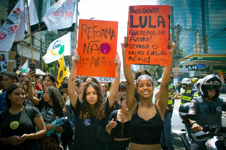 many protesters holding up orange signs and flags