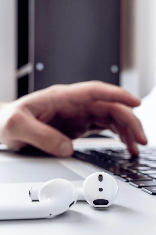 someone's hand holding onto a white wireless ear buds