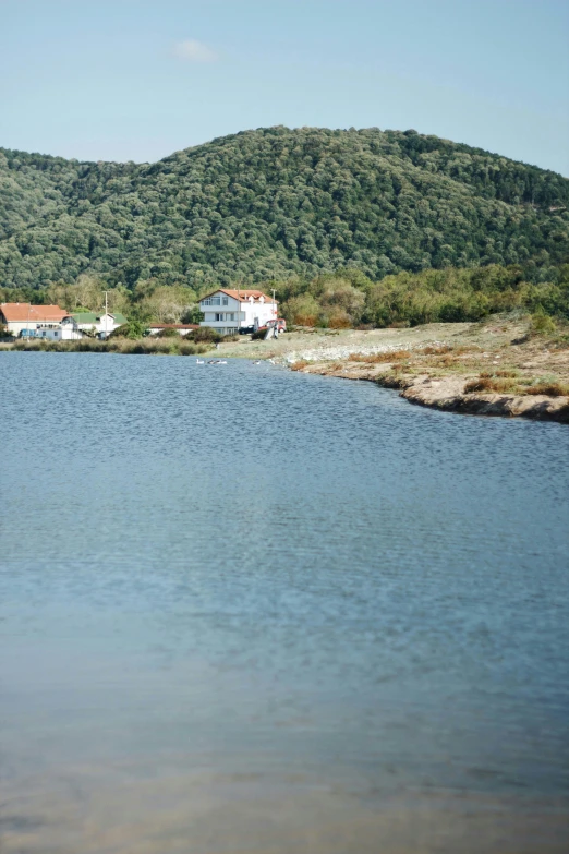 small houses on the edge of water with mountains in background