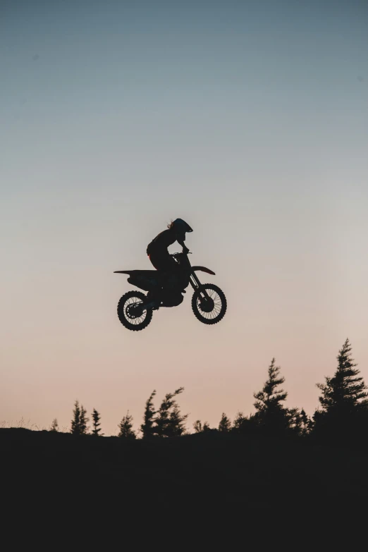 a man flying through the air while riding a dirt bike