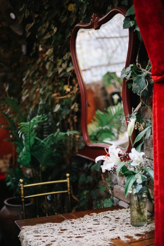 a mirror sitting next to a table covered in flowers