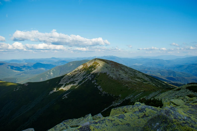 the mountains range over green and rocky terrain