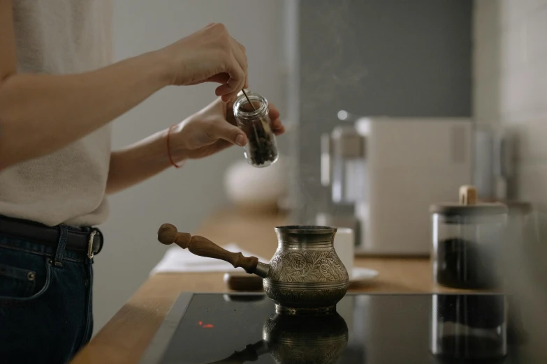 a person is pouring soing into a silver container