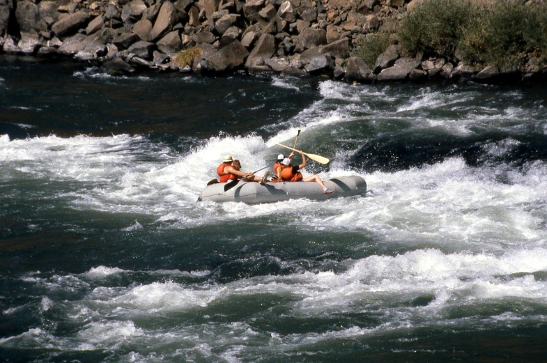 two men are in an inflatable boat on the water