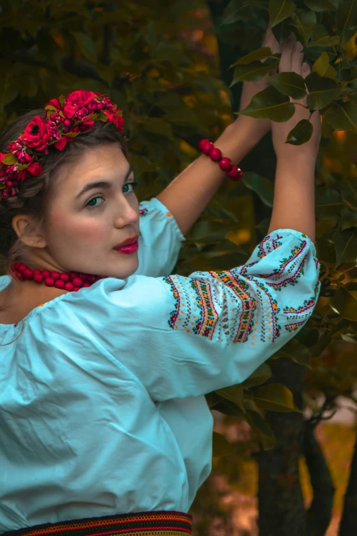 a woman in blue and pink clothes holds a tree