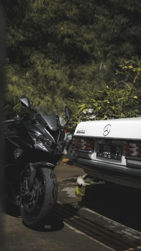 a motorcycle that is next to a parked car