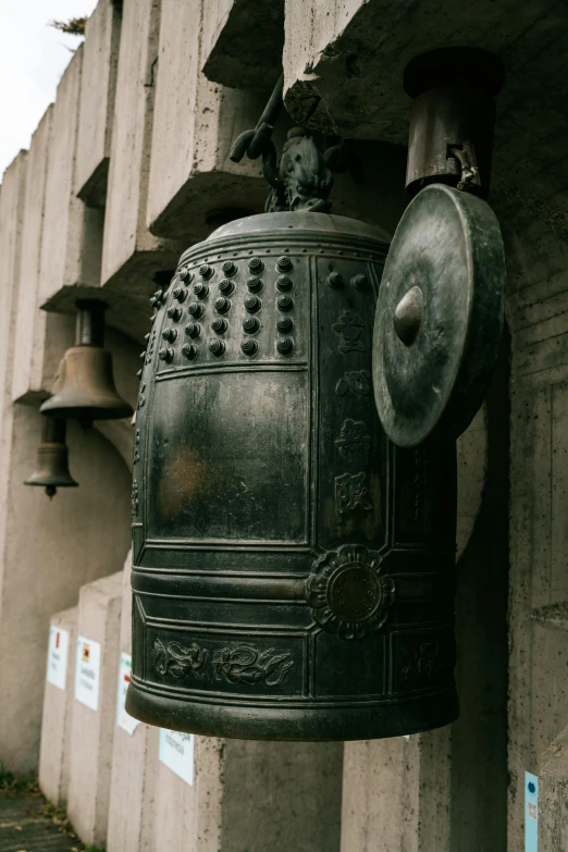 two bells hanging on the side of a wall