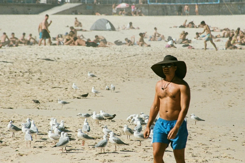 a man with a hat is standing on the beach