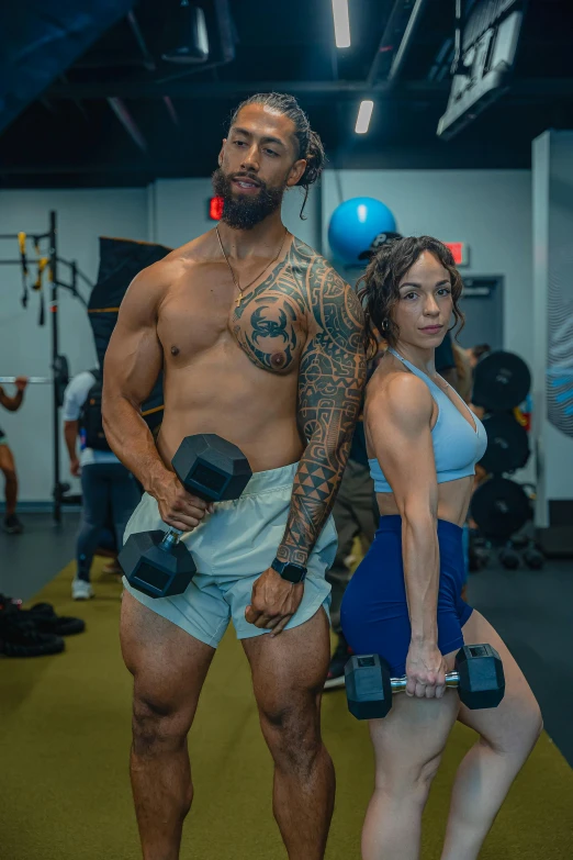 two people in a gym holding dumbs and weights