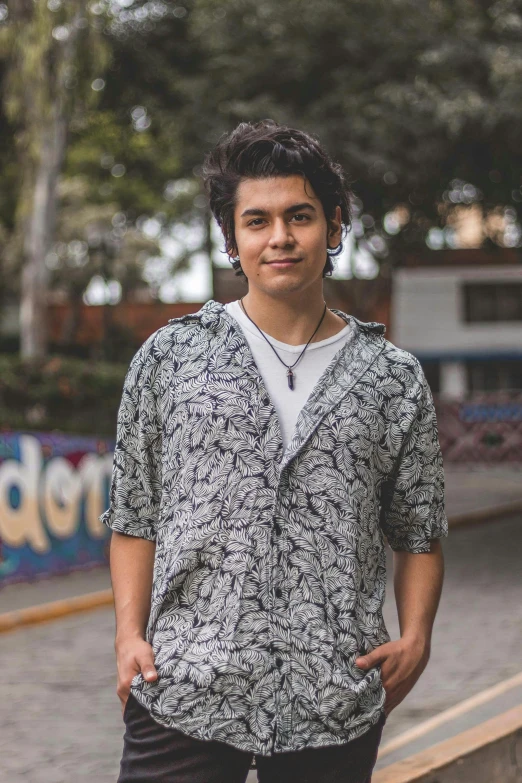 an indian man standing next to the woods in front of a skateboard ramp