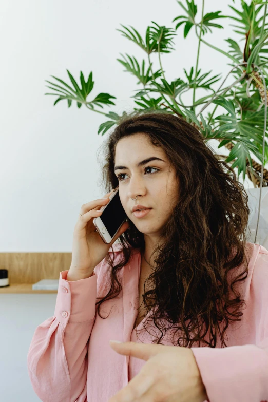 a woman talks on her cellphone and points at a finger