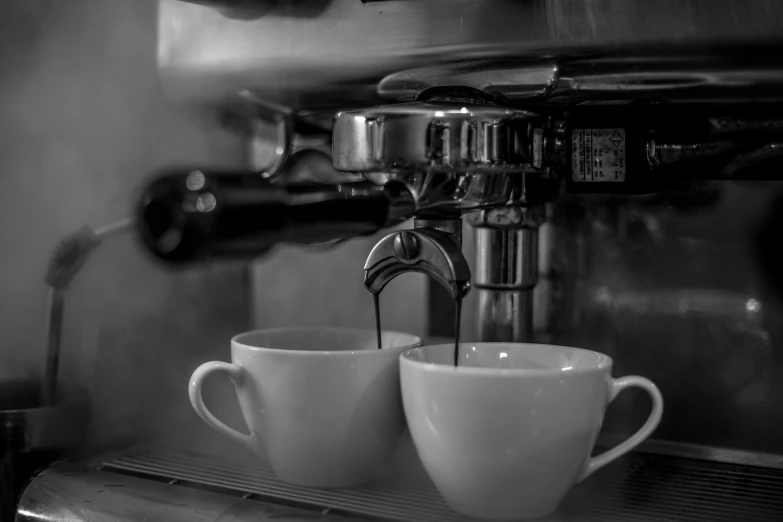 there are cups on a counter being filled with liquid