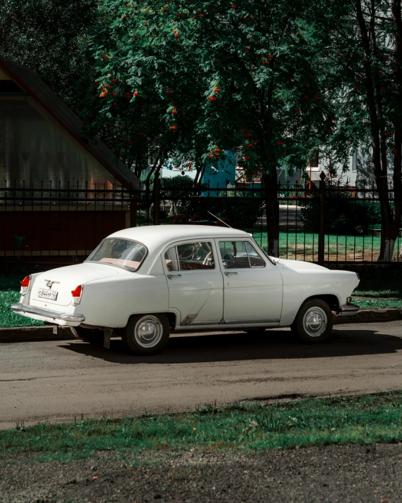 an old car parked in front of a wooden house