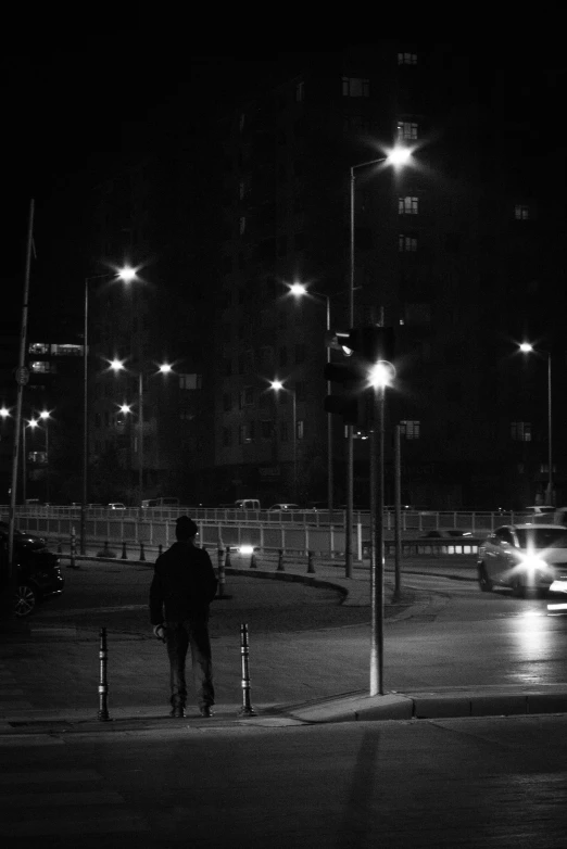 a black and white po with cars going by at night