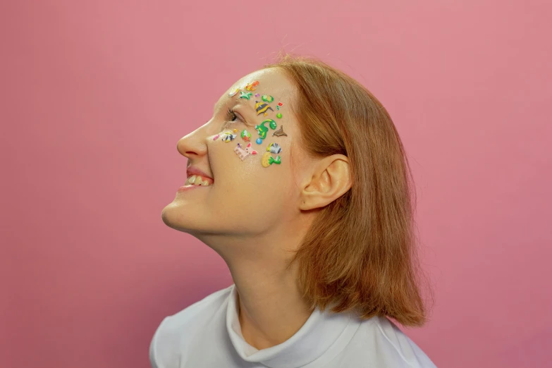 a woman with her face painted in multi colored flowers