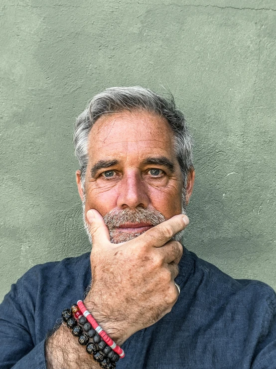 a man with a mustache and bead celet on his wrist