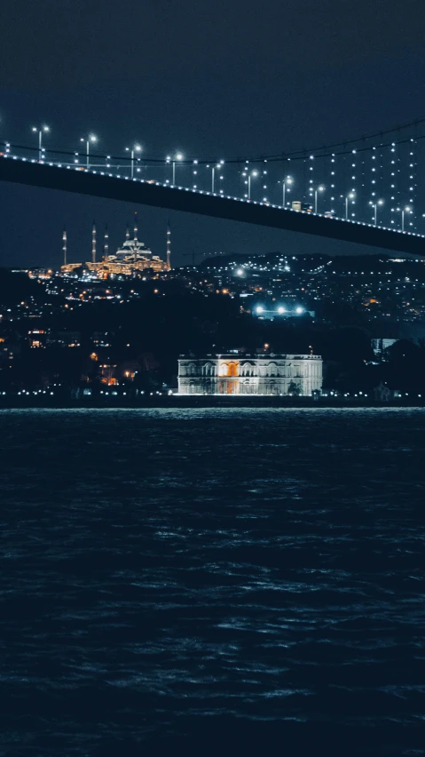 view from the ocean at night with lights reflecting off of water