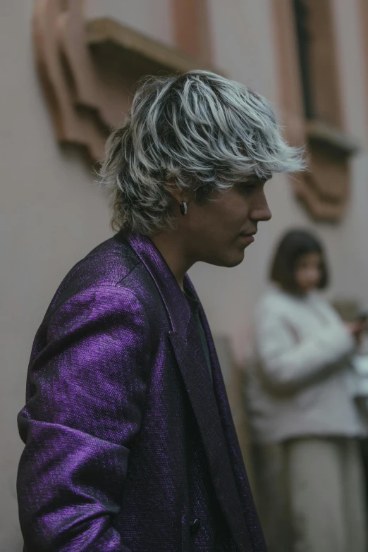 a man with white hair wearing a purple suit and jacket