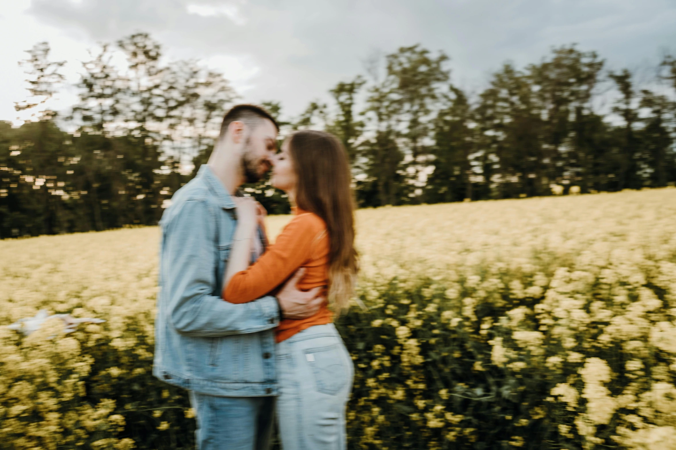 a couple are in the middle of a field with flowers