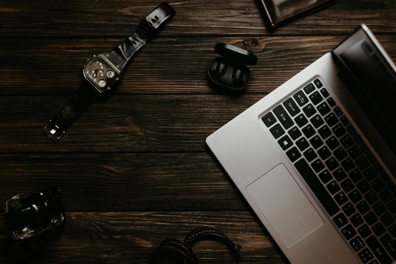 a computer, watch, and camera on a table