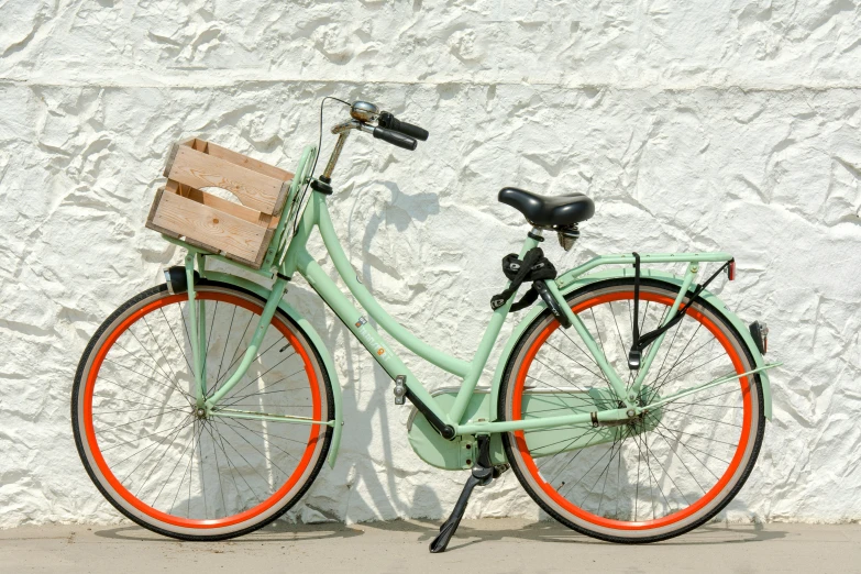 a green bike parked next to a wall