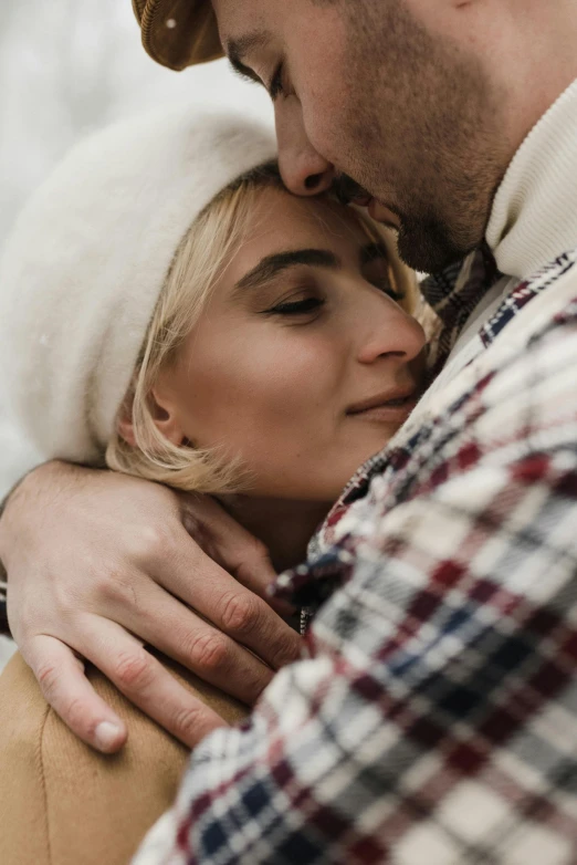 a young couple cuddle during their winter engagement session