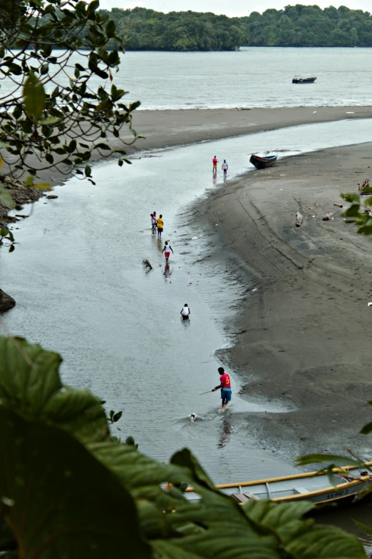 people walking along a water way near some boats